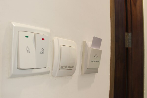 A wall-mounted control panel with a card slot and two buttons. - Citra Suites Surabaya (Surabaya)