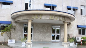 The Jet Hotel entrance with a curved facade, columns, and a signboard. - Jet Hôtel (Douala)