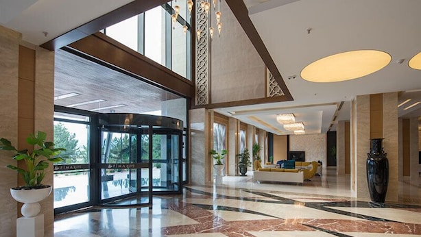 A spacious lobby with a marble floor, a reception desk, and a large vase. - Fimar Life Thermal Resort Hotel (Göynücek)