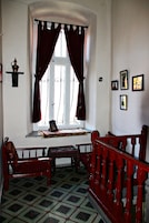 Una habitación con ventana, un banco, una mesa y una escalera.