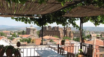 Una terraza con vistas a antiguas murallas y edificios de piedra.