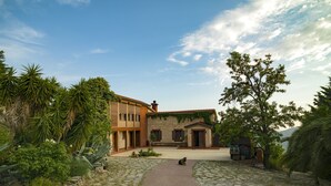 Un patio con un sendero de piedra que lleva a un edificio de techo de tejas y fachada de ladrillo.
