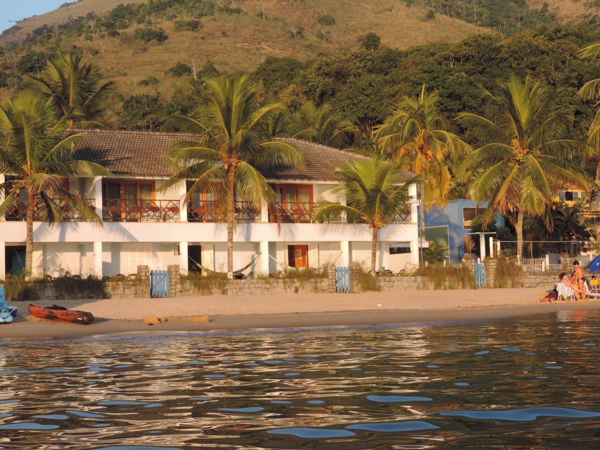 Na praia, areia branca, espreguiçadeiras, guarda-sóis 