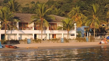 Na praia, areia branca, espreguiçadeiras, guarda-sóis