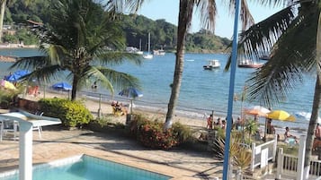 Una piscina al aire libre, sombrillas, sillones reclinables de piscina