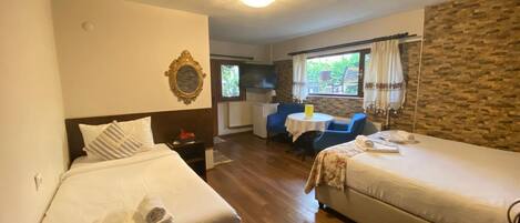Une chambre d’hôtel avec deux lits, une petite table à manger et une vue sur l’extérieur.