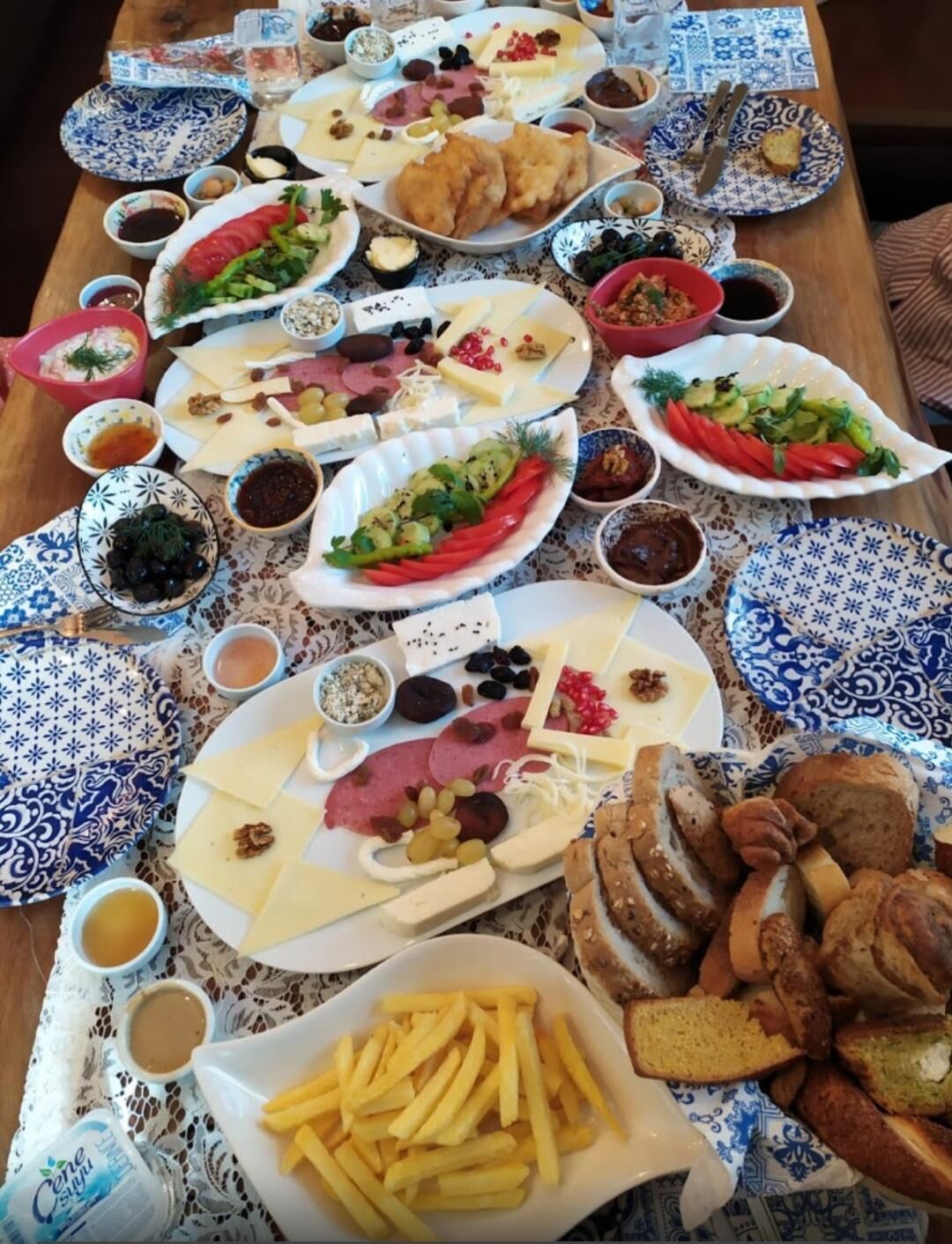 Una mesa con diversos alimentos, como queso, frutas, pan y salsas.