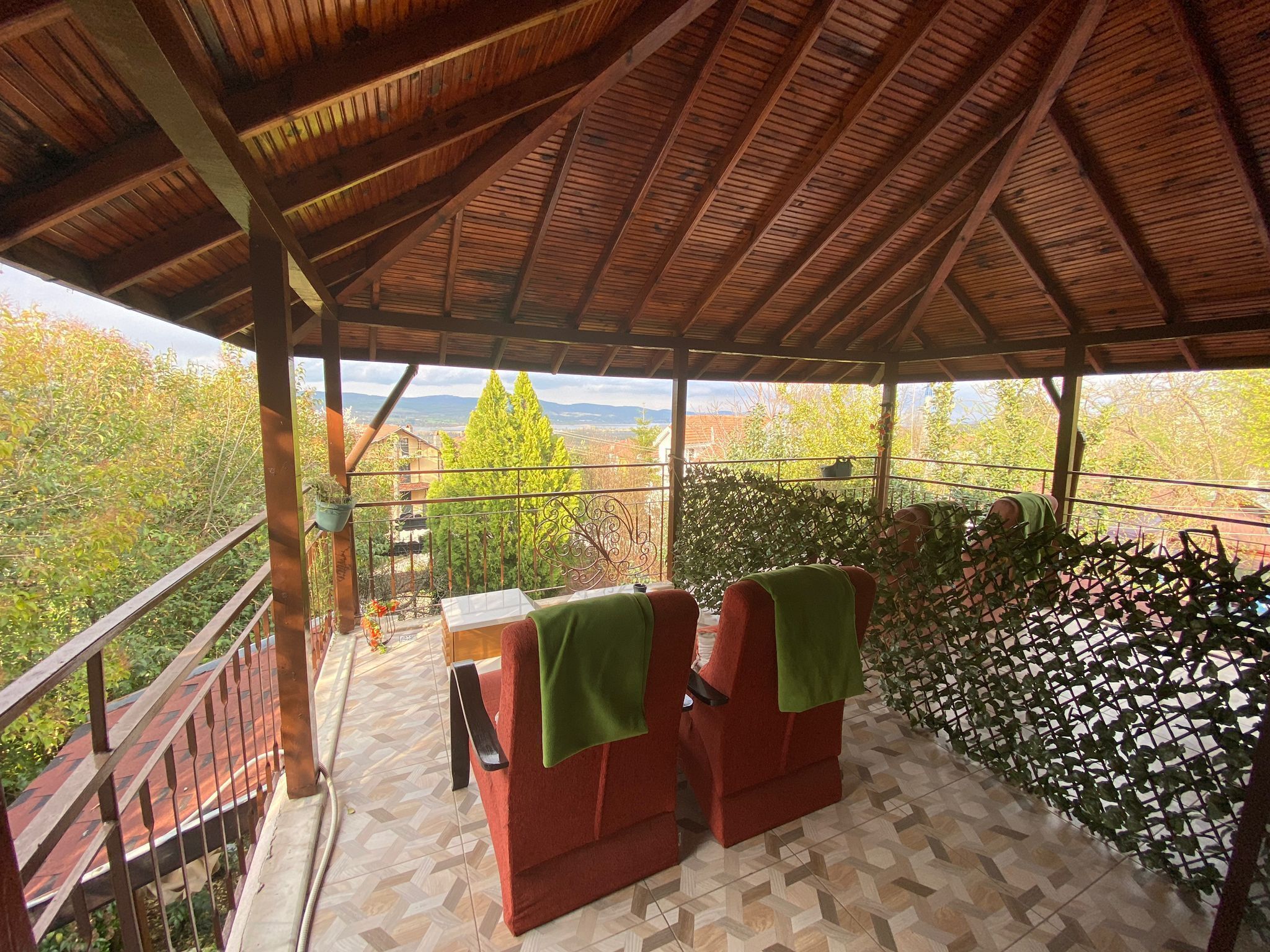 A covered outdoor seating area with a view of the countryside.