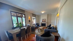 A living room with a fireplace, seating area, and dining space. - Butik Hotel Masukiye (Kartepe)
