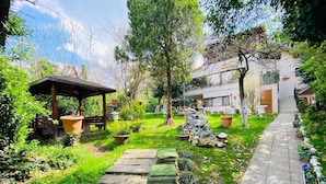 A garden with a wooden pergola, stone steps, and potted plants. - Butik Hotel Masukiye (Kartepe)