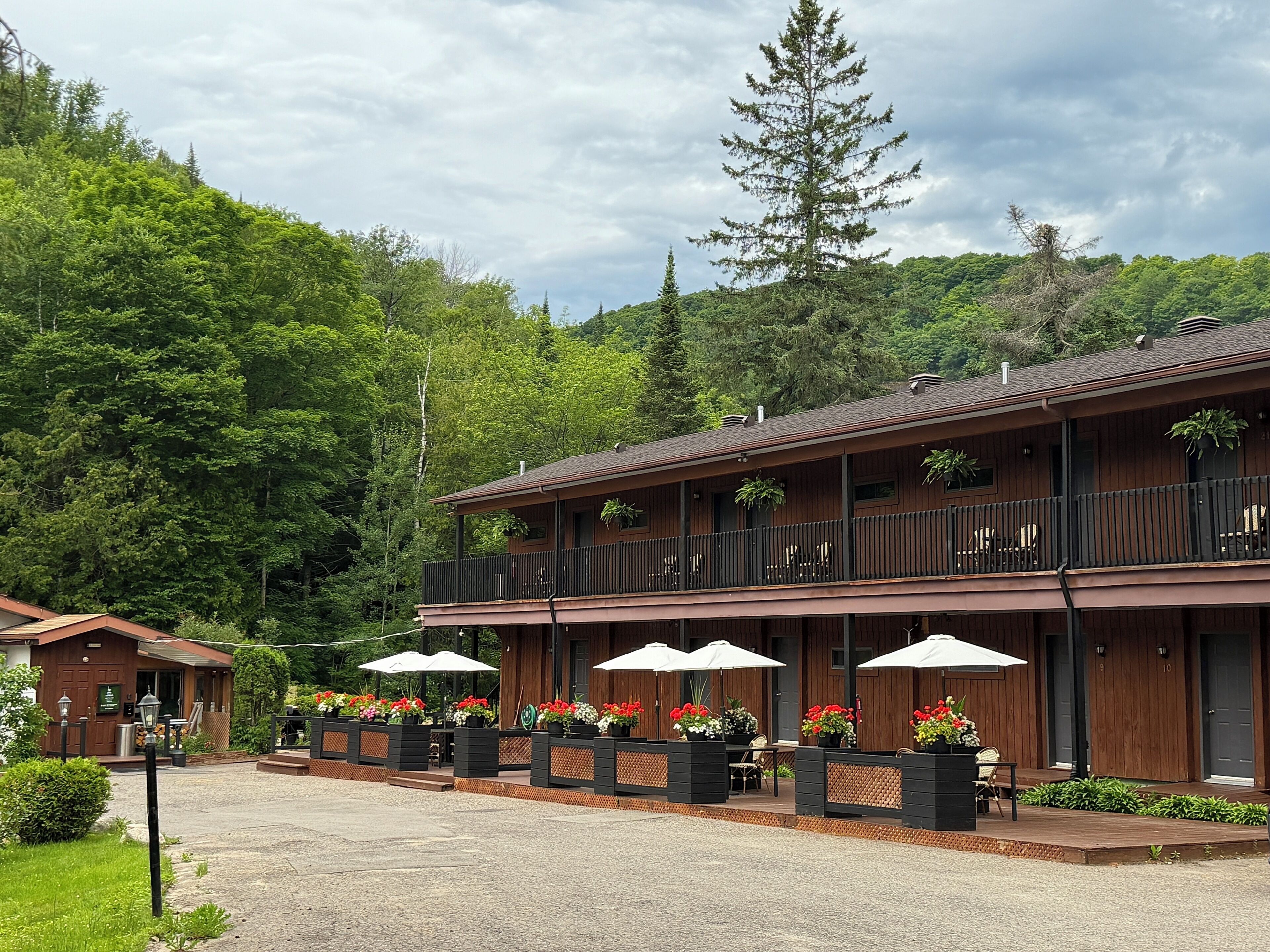 A two-story wooden building with outdoor seating and potted plants.