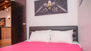 A bedroom with a bed, a painting on the wall, and a wardrobe. - Casa 14 (Medellín)