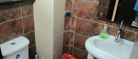 A bathroom with a toilet, sink, and hand dryer.