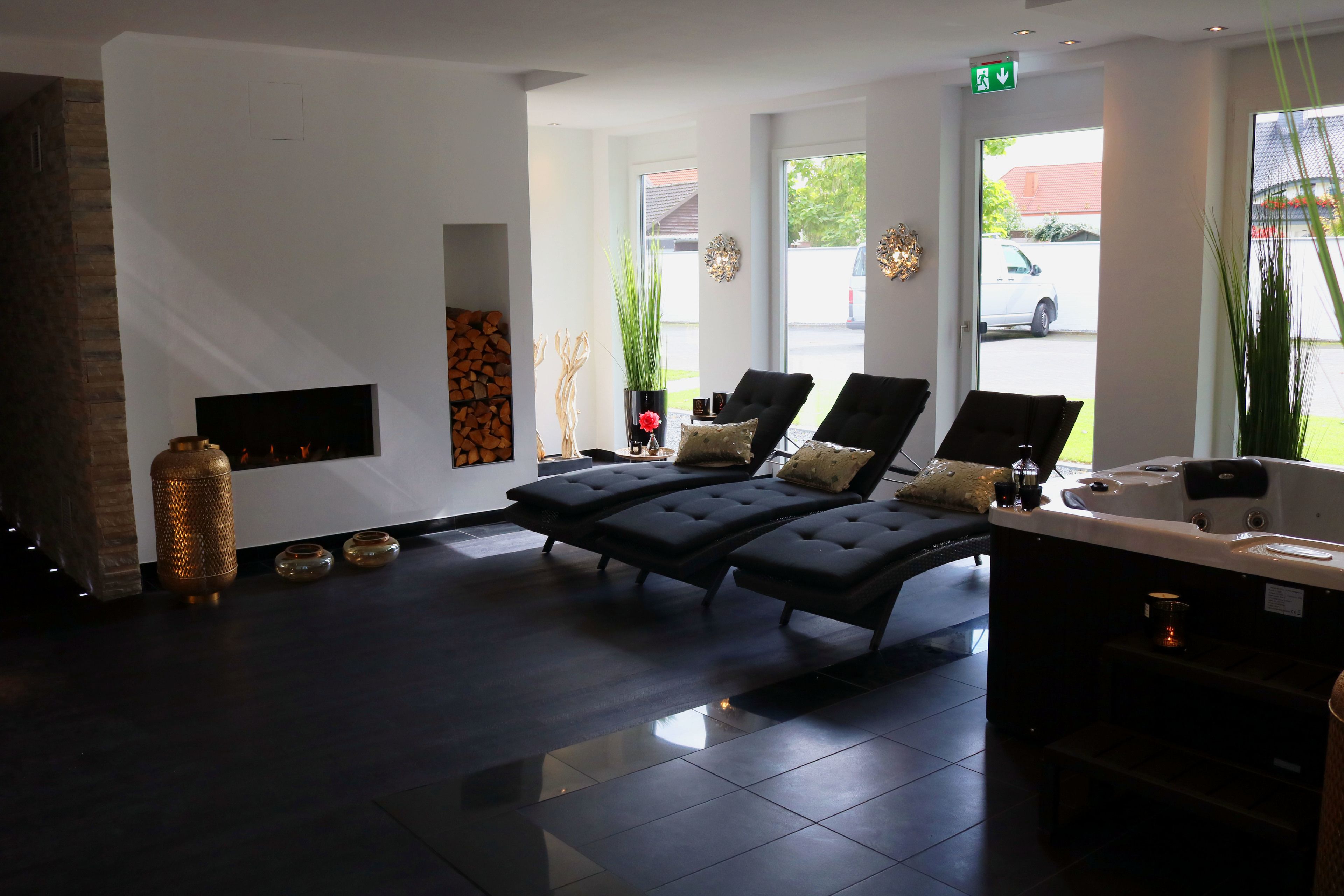 A modern spa area with a fireplace, lounge chairs, and a reception desk.
