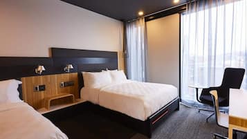 A hotel room with a bed, bedside tables, a desk, and a chair.