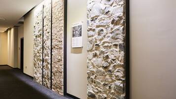 A hallway with stone wall panels and a carpeted floor.