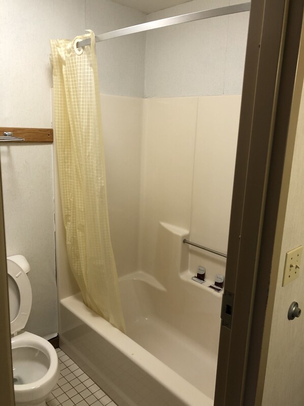 Baño con ducha, inodoro y perchero para toallas.