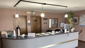 Una mesa de recepción con un letrero que indica que hay habitaciones para fumadores.