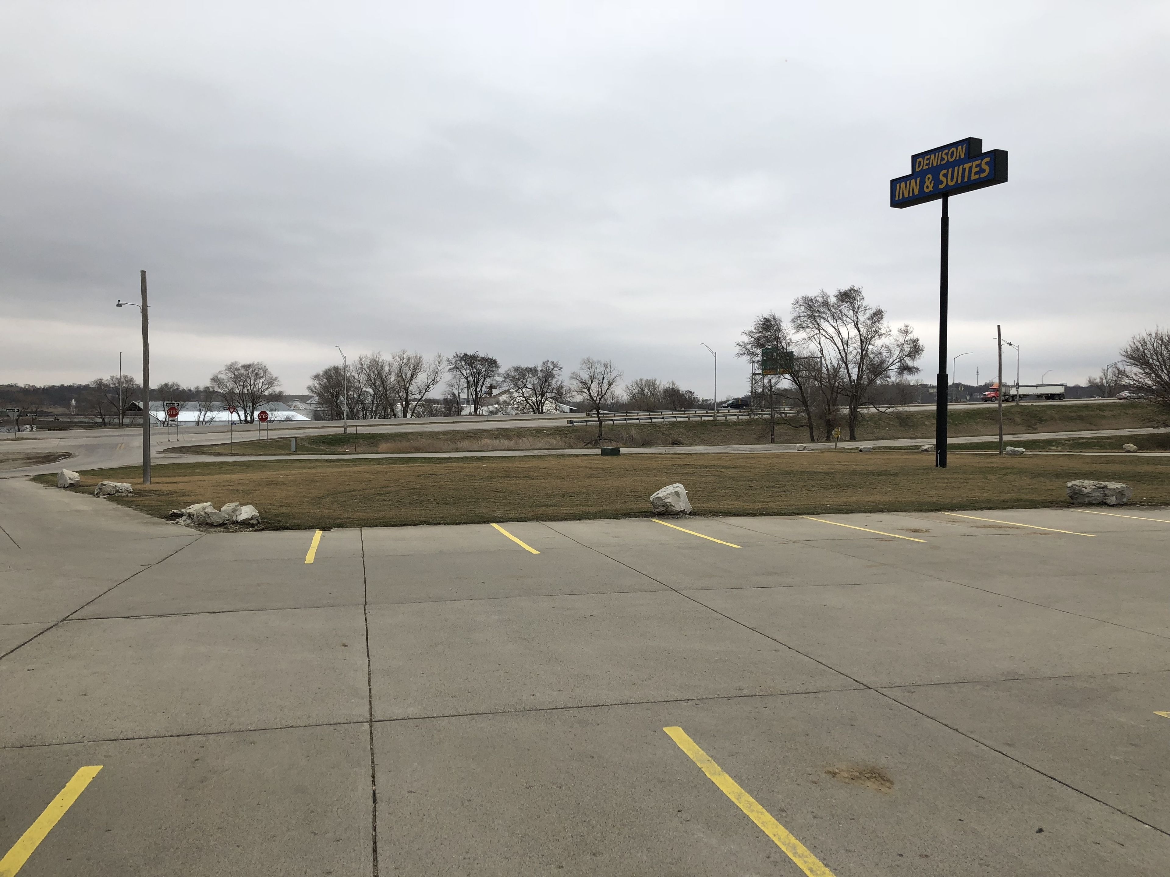 A parking lot with a sign for Denison Inn & Suites.