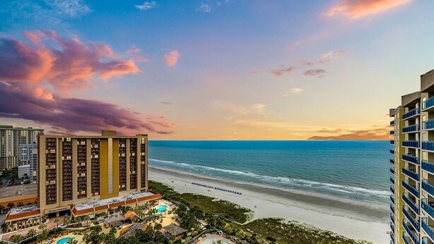 A beachfront hotel with multiple floors, a swimming pool, and a view of the ocean. - Brighton Tower 1909 3br 3ba Oceanfront 3 Bedroom Condo by RedAwning (Myrtle Beach)