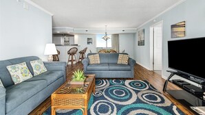 A modern living room with two sofas, a coffee table, a TV, and a patterned rug. - Brighton Tower 1909 3br 3ba Oceanfront 3 Bedroom Condo by RedAwning (Myrtle Beach)