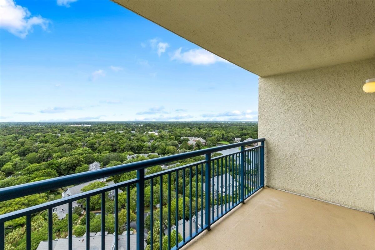 Un balcón con vistas a una zona residencial y un cielo despejado.