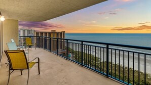 A balcony with chairs and a view of the ocean at sunset. - Brighton Tower 1909 3br 3ba Oceanfront 3 Bedroom Condo by RedAwning (Myrtle Beach)