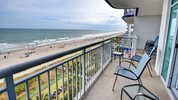 Een balkon met uitzicht op het strand en de oceaan.