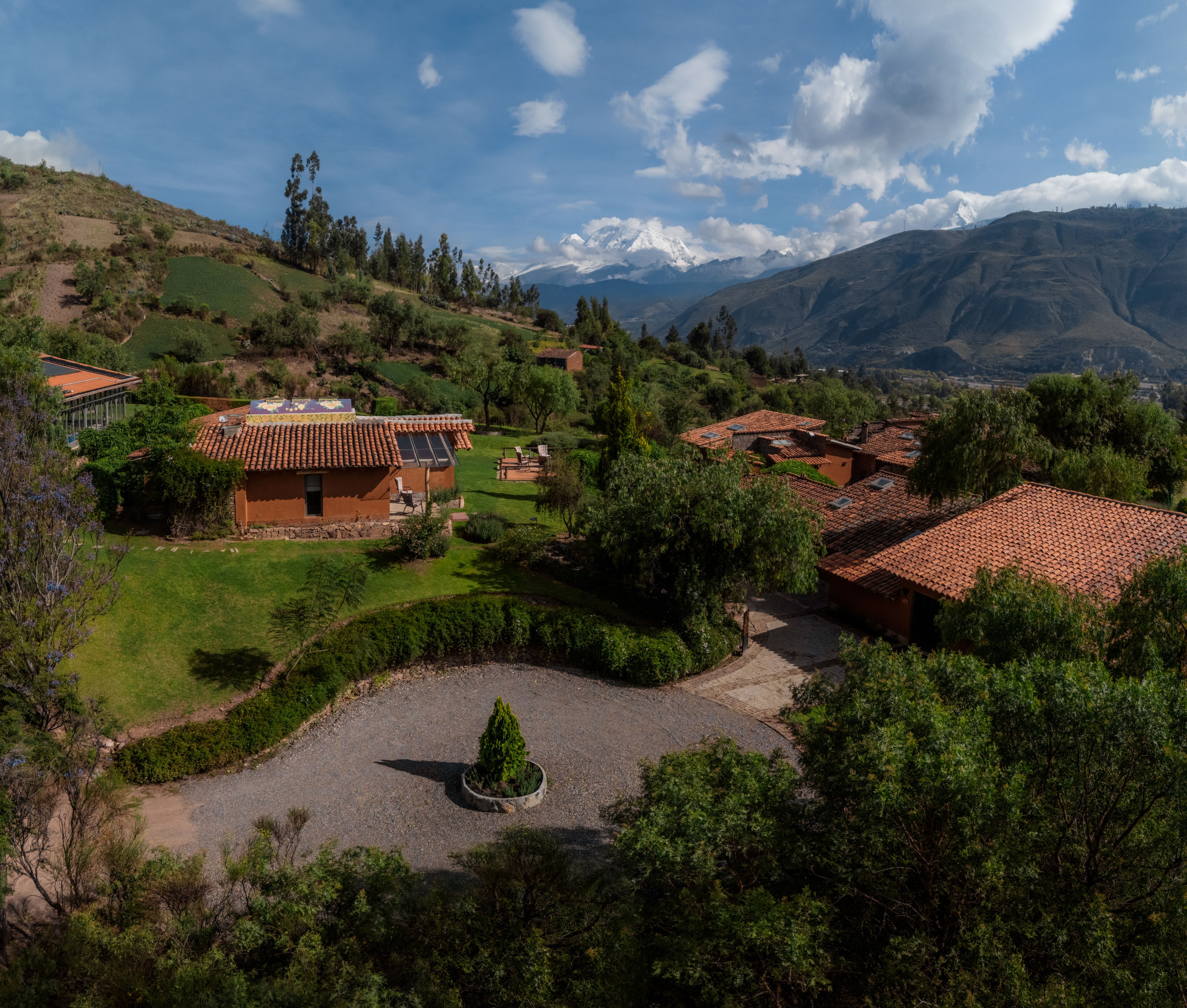 A rural village with traditional houses, terraced fields, and a mountain backdrop.