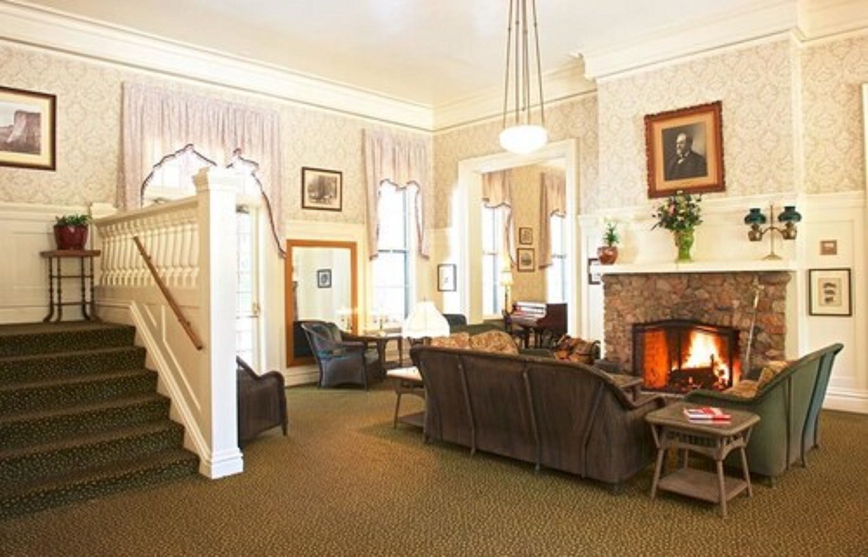 A spacious living room with a fireplace, a staircase, and a cozy seating area.