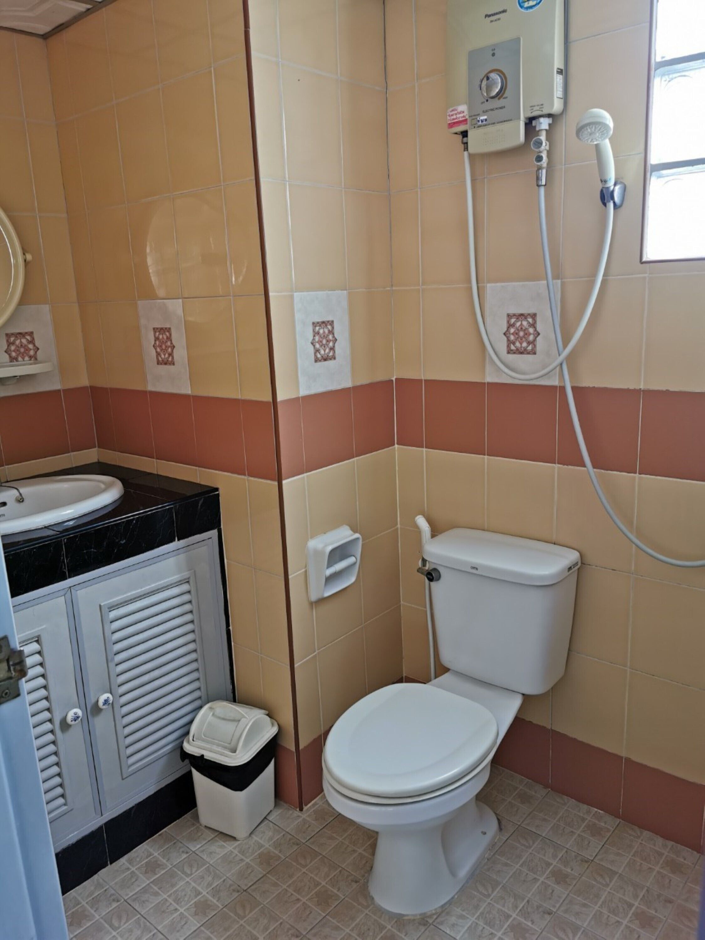 A bathroom with a toilet, a sink, and a shower unit.