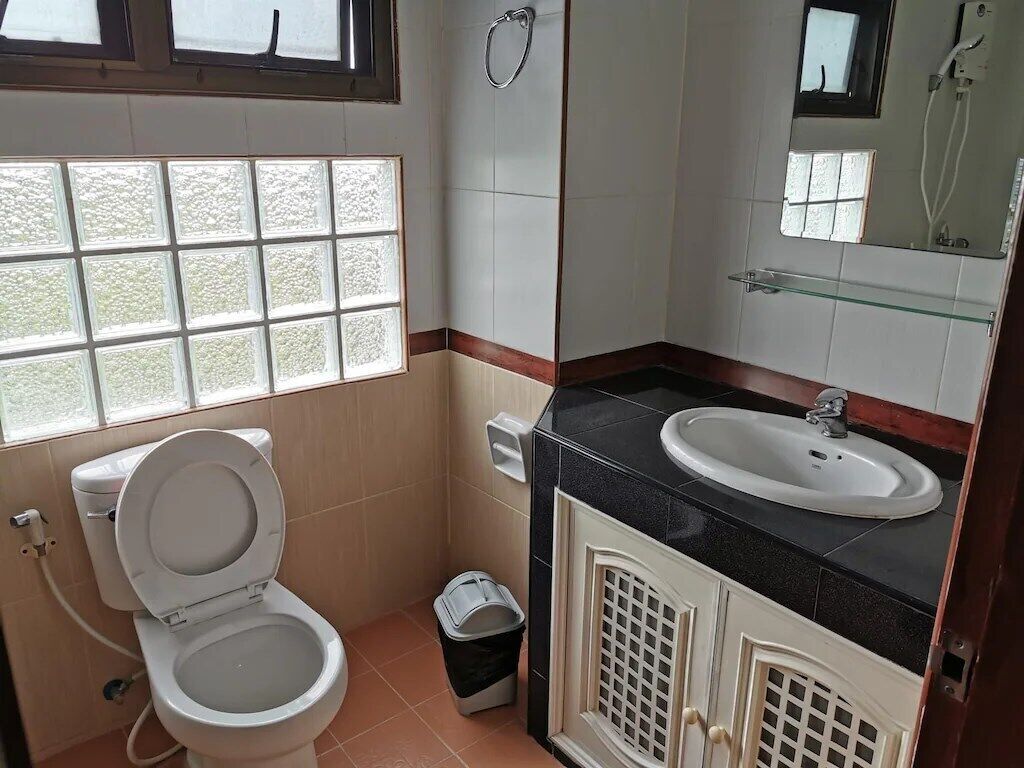 A bathroom with a toilet, sink, and shower.