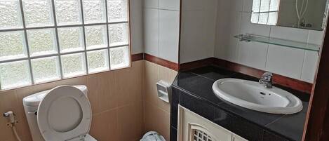 A bathroom with a toilet, sink, and shower.