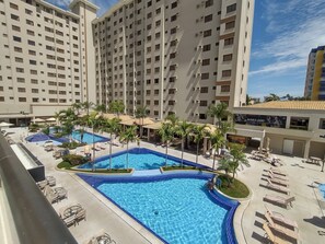 A hotel with multiple swimming pools, palm trees, and lounge chairs. - Boulevard Caldas Novas - Achei Férias (Caldas Novas)