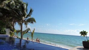 A clear blue pool with a view of the ocean and palm trees. - Casa Moskito, Oceanfront beautiful Villa, 150 Mbps (Playa del Carmen)