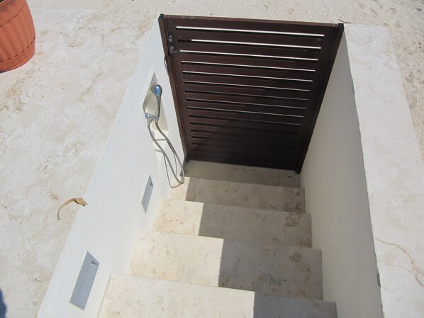 A set of outdoor stairs leading to a dark wooden door, with a metal handrail on the left. - Casa Moskito, Oceanfront beautiful Villa, 150 Mbps (Playa del Carmen)
