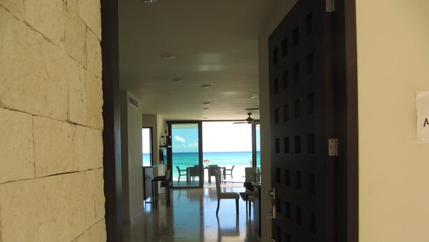A hallway leading to a dining area with a view of the ocean. - Casa Moskito, Oceanfront beautiful Villa, 150 Mbps (Playa del Carmen)