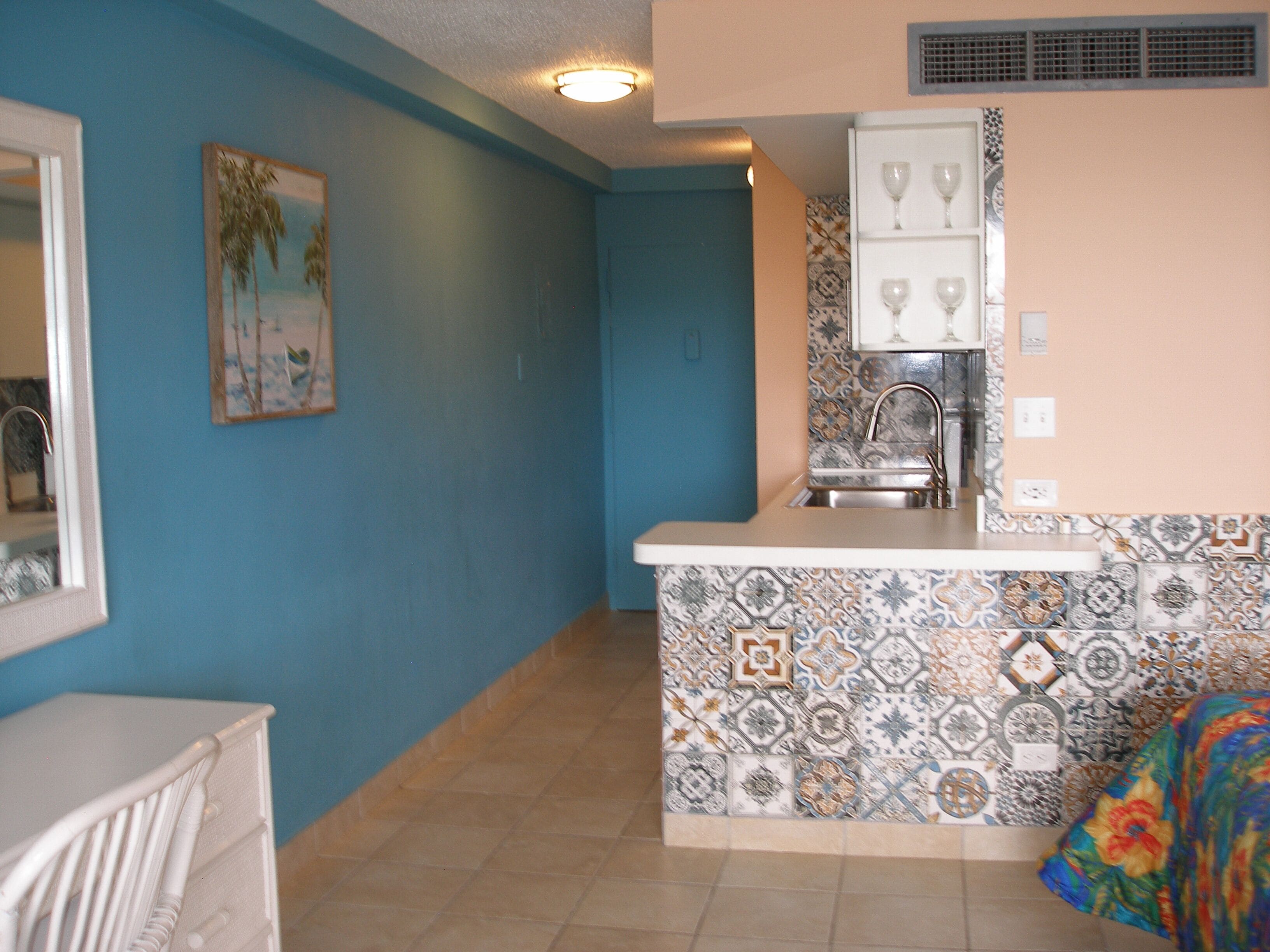 A kitchen with a tiled backsplash, a sink, and a countertop.
