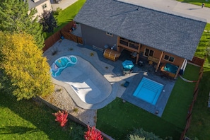 Luchtbeeld van een huis met een zwembad, een jacuzzi en een terras.