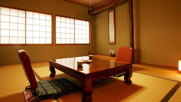 A traditional Japanese room with tatami flooring, a low wooden table, a red chair, and sliding shoji doors. - Park Lodge Sekine (Myoko)