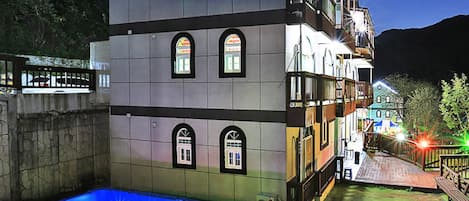A multi-story building with a swimming pool on the ground floor.