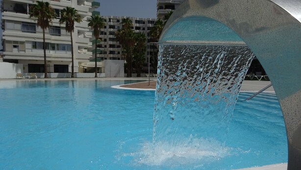 A swimming pool with a water feature.
