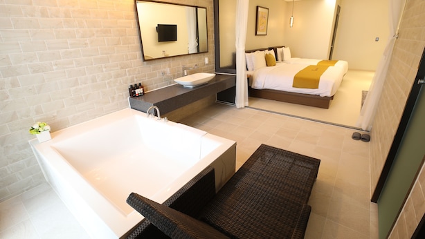 Une salle de bain moderne avec une grande baignoire, un lavabo et un miroir.