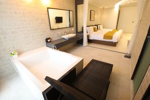A modern bathroom with a large bathtub, a sink, and a mirror. - Rest Hotel (Gimpo)