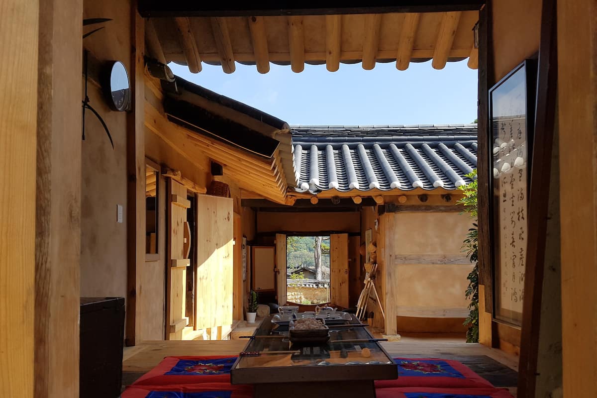 A traditional Japanese-style room with tatami mats, a low table, and a sliding door.
