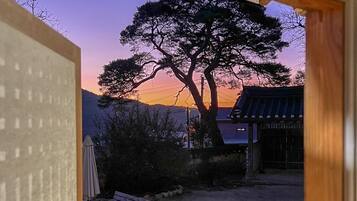 Un edificio japonés tradicional con un gran árbol al fondo.