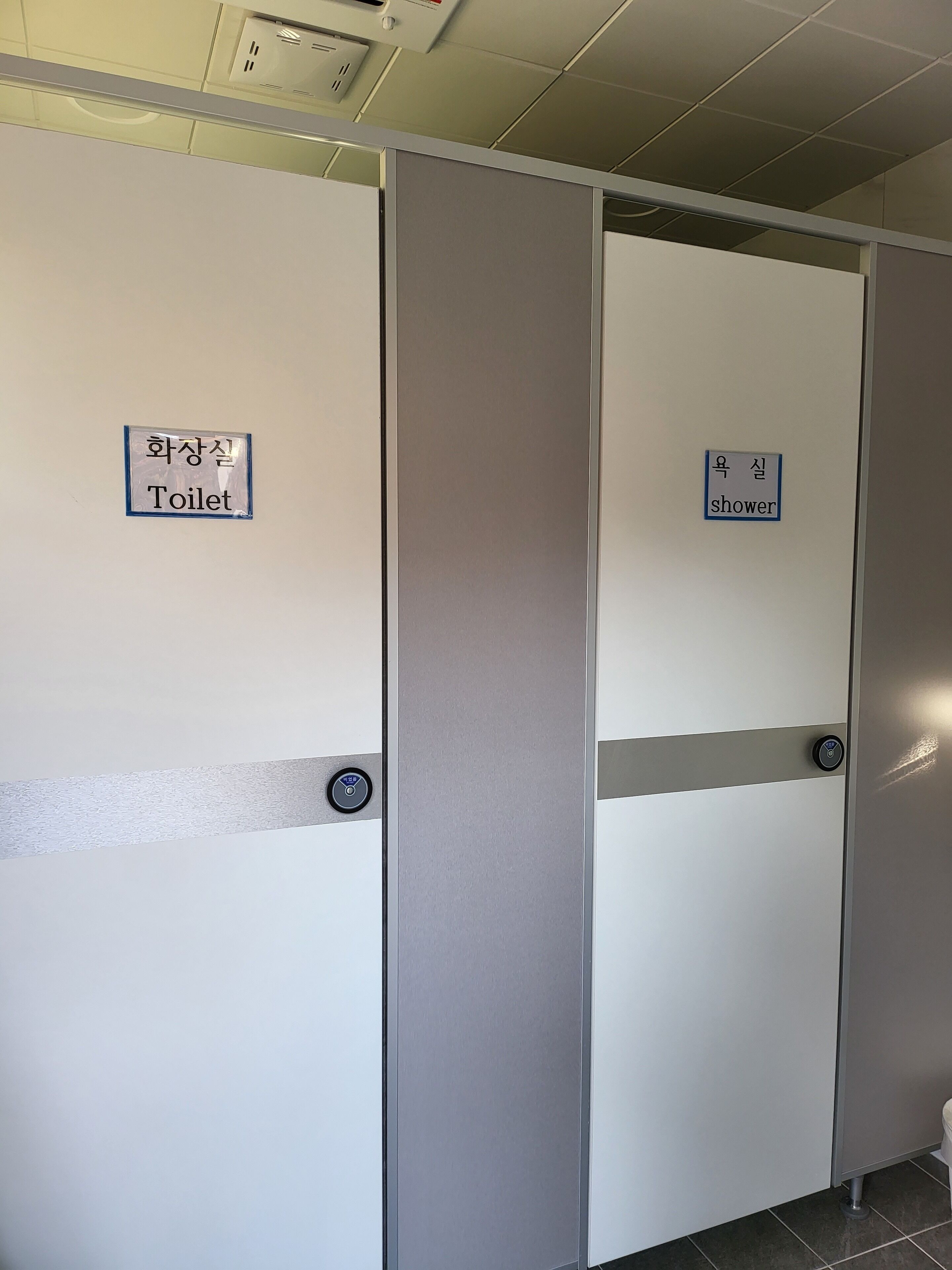 A set of doors with labels indicating a toilet and a shower.