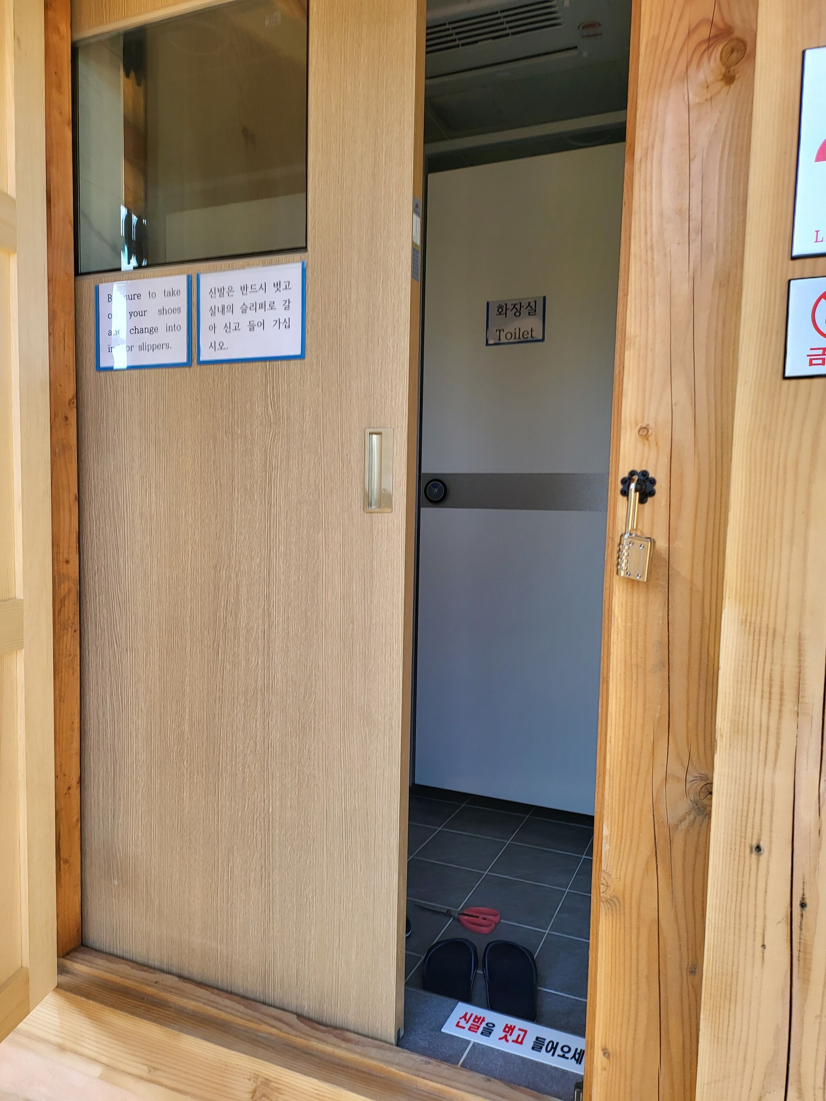 A wooden door with a sign indicating a toilet.