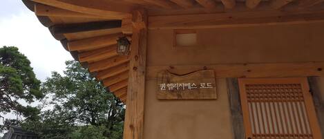 A traditional wooden structure with a tiled roof and a wooden signboard.
