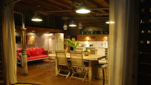 A cozy interior with a dining area, a kitchen, and a living space featuring wooden floors and modern furnishings. - Luxury villa with pool on an ancient sugarcane plantation (LAMENTIN)